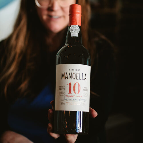 Ellie Mullins holding a bottle of Tawny Port at P&E Bottle Shop in Three Oaks, Michigan
