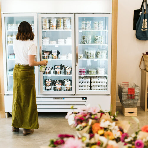 A woman shops local produce and specialty cheese at Farmette in New Buffalo, Michigan