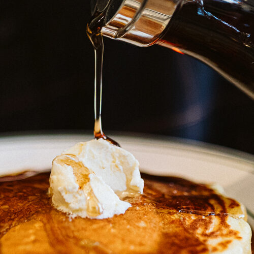 Syrup pours on a mountain of butter atop a pancake at Viola Cafe in Three Oaks, Michigan.