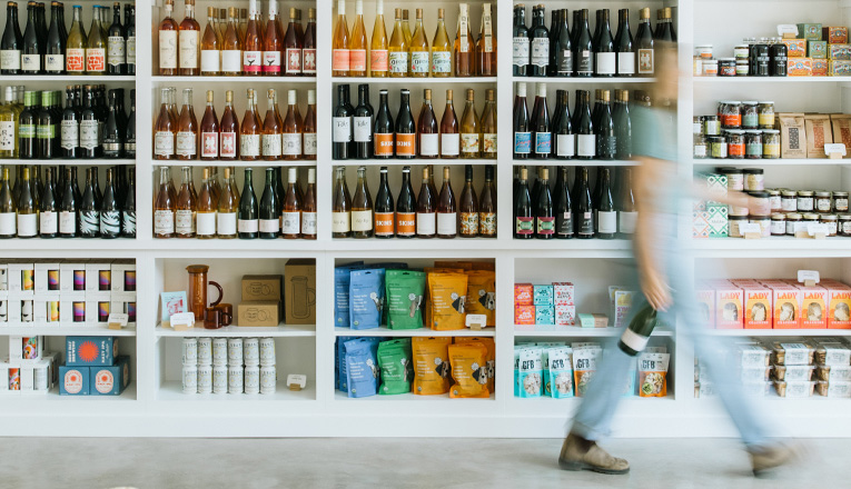 A motion blur of a woman in front of stocked shelves of wine at Farmette in New Buffalo, Michigan