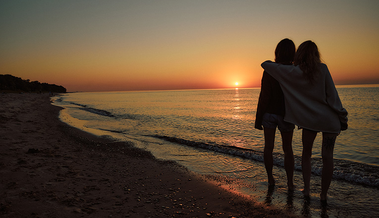 Two friends watch the sunset near the shore of Lake Michigan
