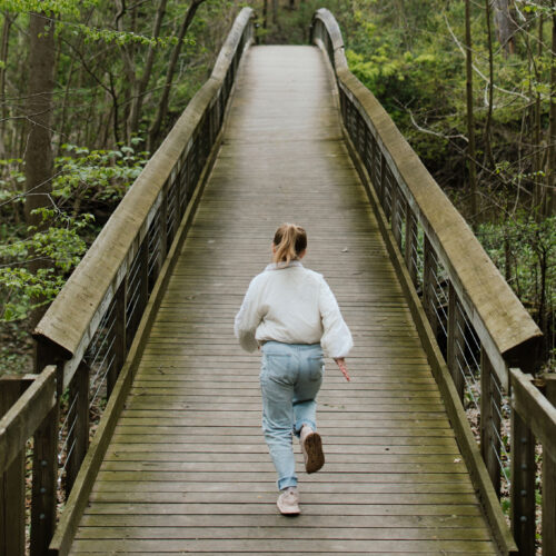 A girl running over a bridge at Warren Woods State Park in Sawyer, Michigan