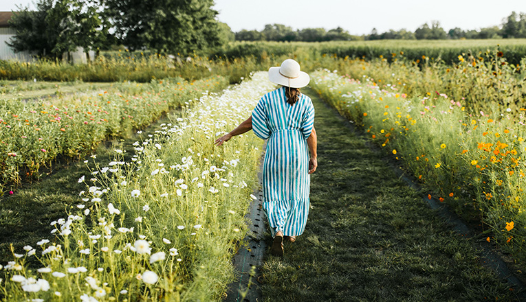 A woman walks in a field of blooming flowers at Homecamp in Three Oaks, Michigan