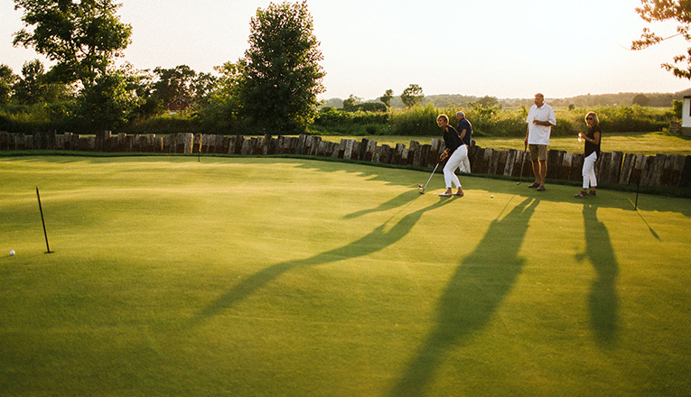A foursome putting on the green at Journeyman in Three Oaks, Michigan