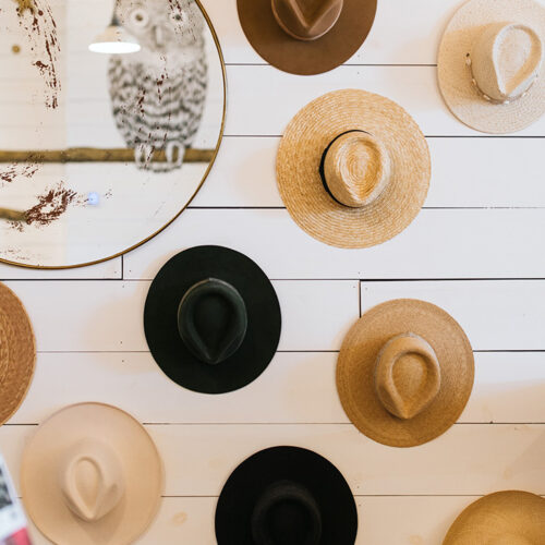 Straw and cowboy hats hang on display at Eastern Standard Time in New Buffalo, Michigan