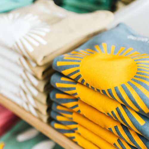 A stack of graphic sun sweatshirts at Eastern Standard Time in New Buffalo, Michigan