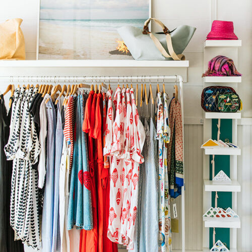 Sundresses and chic beachwear hangs on racks under a beach bonfire photo at Lake Feste in New Buffalo, Michigan