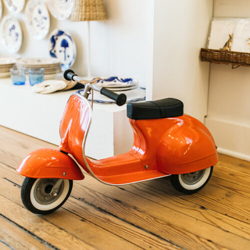 A tiny red moped waits for a toddler at Lakeside Goods in New Buffalo, Michigan