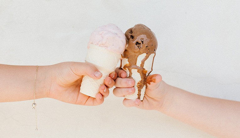 Two hands cheers ice cream cones at Neon Moon Gelato in Union Pier, Michigan