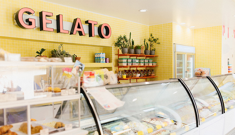 The bright interior with a 'Gelato' sign at Neon Moon Gelato in Union Pier, Michigan
