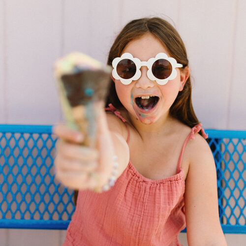 A girl smiles and holds up an ice cream cone at Oinks Dutch Treat in New Buffalo, Michigan