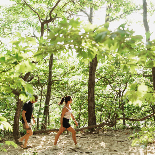 Two friends walk through a wooded path along the Mt. Randall Loop trail at Warren Dunes State Park in Sawyer, Michigan