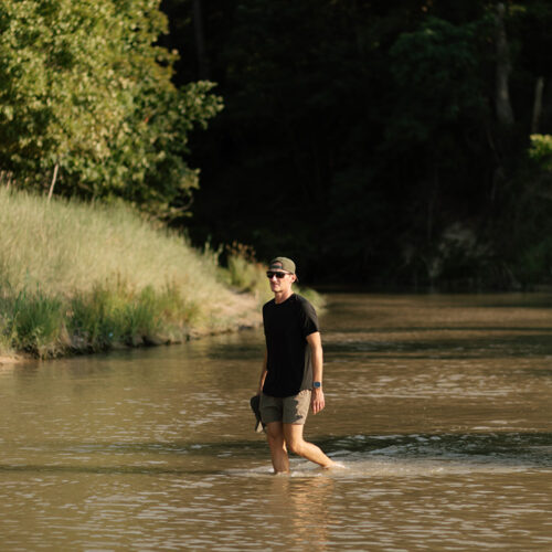 A man walking through a river at Warren Dunes State Park in Sawyer, Michigan